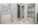 A hallway leads to a bathroom, closet, and carpeted room with natural light streaming through the windows at 5048 Sw 57Th Pl, Ocala, FL 34474