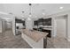 Kitchen featuring stainless steel appliances, dark wood cabinets, and a large granite island at 5048 Sw 57Th Pl, Ocala, FL 34474