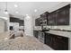 Modern kitchen featuring dark cabinets, granite countertops, tile floors, and stainless steel appliances at 5048 Sw 57Th Pl, Ocala, FL 34474