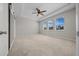 Bright main bedroom featuring neutral walls, plush carpeting, tray ceiling, and windows at 5048 Sw 57Th Pl, Ocala, FL 34474