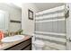 Bathroom features a single vanity, shower and tub with horizontally striped curtain at 6 Diamond Cove Ct, Ocala, FL 34472