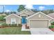 Gorgeous one-story home with a two-car garage, a vibrant blue front door, and manicured landscaping at 6 Diamond Cove Ct, Ocala, FL 34472