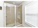 Bathroom shower featuring glass doors, tile surround, and a shower head at 6 Diamond Cove Ct, Ocala, FL 34472