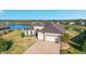 Single-story house aerial view, featuring a paver driveway, attached two-car garage, and lake view at 6558 Sw 94Th Cir, Ocala, FL 34481