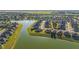 Aerial view of a beautiful community showcases homes situated along a scenic lake with lush surroundings at 6558 Sw 94Th Cir, Ocala, FL 34481