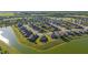 Aerial view of a beautiful community showcases homes situated along a scenic lake with lush surroundings at 6558 Sw 94Th Cir, Ocala, FL 34481