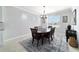 A dining room features an area rug with natural light from a window and chandelier lighting at 6558 Sw 94Th Cir, Ocala, FL 34481
