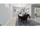 A dining room features a light fixture with natural light from a window and decor hanging on the wall at 6558 Sw 94Th Cir, Ocala, FL 34481