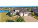 Expansive single-story home with mature landscaping, a paver driveway, and a serene lake view at 6558 Sw 94Th Cir, Ocala, FL 34481
