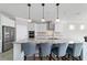 Modern kitchen with stainless steel appliances, large island, and pendant lights for an elegant touch at 6558 Sw 94Th Cir, Ocala, FL 34481