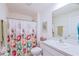 Clean bathroom featuring floral shower curtain, a well-lit mirror, and organized vanity space at 6933 Se 111Th Ln, Belleview, FL 34420