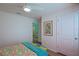 Bright bedroom showcasing floral bedding, wood floors, and a white door that enhances the room's charm at 6933 Se 111Th Ln, Belleview, FL 34420