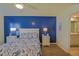 A bedroom features a blue accent wall, a ceiling fan, and complementary decor at 6933 Se 111Th Ln, Belleview, FL 34420