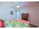 Bedroom featuring tropical bedspread, wood floors, and view of a classic wood dresser at 6933 Se 111Th Ln, Belleview, FL 34420
