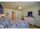 Comfortable bedroom with blue and white bedding, ceiling fan, and a dresser with mirror at 6933 Se 111Th Ln, Belleview, FL 34420