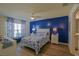 A bedroom features a blue accent wall, a ceiling fan, and complementary decor at 6933 Se 111Th Ln, Belleview, FL 34420