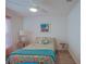 Bright bedroom featuring floral bedding, ceiling fan, and beach-themed artwork for a relaxing ambiance at 6933 Se 111Th Ln, Belleview, FL 34420