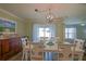 A dining area is furnished with white chairs and table that has decorative window treatments at 6933 Se 111Th Ln, Belleview, FL 34420