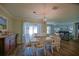 A dining area is furnished with white chairs and table next to sliding glass doors at 6933 Se 111Th Ln, Belleview, FL 34420
