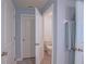 Hallway with multiple white doors and view of a toilet in an opened door at 6933 Se 111Th Ln, Belleview, FL 34420