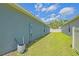 Property's side yard features a tidy lawn and utility connections with a clean, fenced boundary at 6933 Se 111Th Ln, Belleview, FL 34420