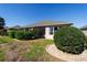 Backyard view shows the back of the house, manicured bushes, and well-kept lawn at 7283 Sw 94Th Ave, Ocala, FL 34481