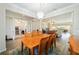 Bright dining room with a wooden table, chandelier, and an adjacent view of a living area and office space at 7283 Sw 94Th Ave, Ocala, FL 34481