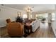 Inviting living room featuring hardwood floors, a ceiling fan, comfortable seating, and a view of an outdoor patio at 7283 Sw 94Th Ave, Ocala, FL 34481