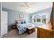 Bright main bedroom with blue accents, a comfortable queen bed, and a view of the well-manicured backyard at 7283 Sw 94Th Ave, Ocala, FL 34481