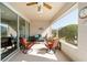 Relaxing screened patio featuring comfortable seating, ceiling fan, and sliding glass doors for seamless indoor-outdoor living at 7283 Sw 94Th Ave, Ocala, FL 34481
