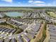 This aerial shot shows single-Gathering homes nestled within a community with a lake, trees, and manicured golf courses at 7665 Sw 96Th Avenue Rd, Ocala, FL 34481