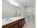 Bathroom with dual vanity, large mirror, and glass-enclosed shower at 7665 Sw 96Th Avenue Rd, Ocala, FL 34481