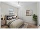 Comfortable bedroom with a large bed, neutral carpet, ceiling fan, and ample natural light at 7665 Sw 96Th Avenue Rd, Ocala, FL 34481