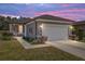 Charming home exterior featuring a two-car garage, manicured landscaping, and a pathway to the front door at 7665 Sw 96Th Avenue Rd, Ocala, FL 34481