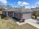 An eye-level, slightly elevated front exterior, showing a two-car garage, manicured landscaping and neutral paint scheme at 7665 Sw 96Th Avenue Rd, Ocala, FL 34481