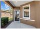 Inviting front entrance with a glass storm door and a glimpse of the landscaped yard at 7665 Sw 96Th Avenue Rd, Ocala, FL 34481