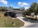 Beautifully landscaped single-story home featuring a gray color scheme and a two-car garage at 7665 Sw 96Th Avenue Rd, Ocala, FL 34481