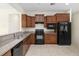 This kitchen is equipped with black appliances, granite countertops, and wood cabinetry at 7665 Sw 96Th Avenue Rd, Ocala, FL 34481