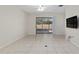 Bright and spacious living area with tile flooring, ceiling fan, and sliding glass doors to the backyard at 7665 Sw 96Th Avenue Rd, Ocala, FL 34481