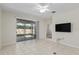 Open floor plan with tile flooring, backyard patio access, and a mounted television for easy viewing at 7665 Sw 96Th Avenue Rd, Ocala, FL 34481
