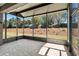 Enclosed patio area with paver flooring, offering a view of the landscaped backyard with trees and shrubs at 7665 Sw 96Th Avenue Rd, Ocala, FL 34481