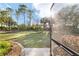 Spacious backyard featuring lush green grass, landscaping, and partial view of the screened-in patio at 8344 Sw 79Th Cir, Ocala, FL 34476