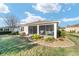 Exterior view showcasing the screened-in porch, manicured lawn, and verdant landscaping at 8344 Sw 79Th Cir, Ocala, FL 34476