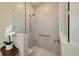 Walk-in shower boasts neutral tile, glass enclosure, and convenient grab bar, blending style with accessibility at 8344 Sw 79Th Cir, Ocala, FL 34476