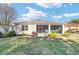 Rear exterior view of the home showcasing a screened-in patio and well-maintained lawn and landscaping at 8344 Sw 79Th Cir, Ocala, FL 34476