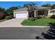 Well-maintained single-story home featuring a paved driveway, manicured lawn, and inviting front porch with seating at 8344 Sw 79Th Cir, Ocala, FL 34476