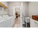Functional laundry room with washer, dryer, sink, shelving, and easy access to the home's living area at 8344 Sw 79Th Cir, Ocala, FL 34476