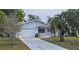 Well-maintained single-story home with an attached garage, beautiful landscaping, and a long driveway at 8449 Sw 106Th Pl, Ocala, FL 34481