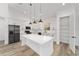 Bright kitchen featuring white cabinetry, a large island, stainless steel appliances, and modern pendant lighting at 8850 Sw 125Th Ter, Dunnellon, FL 34432