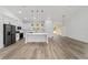 Open-concept kitchen features stainless steel appliances, a large island, pendant lighting, and luxury vinyl plank flooring at 8850 Sw 125Th Ter, Dunnellon, FL 34432